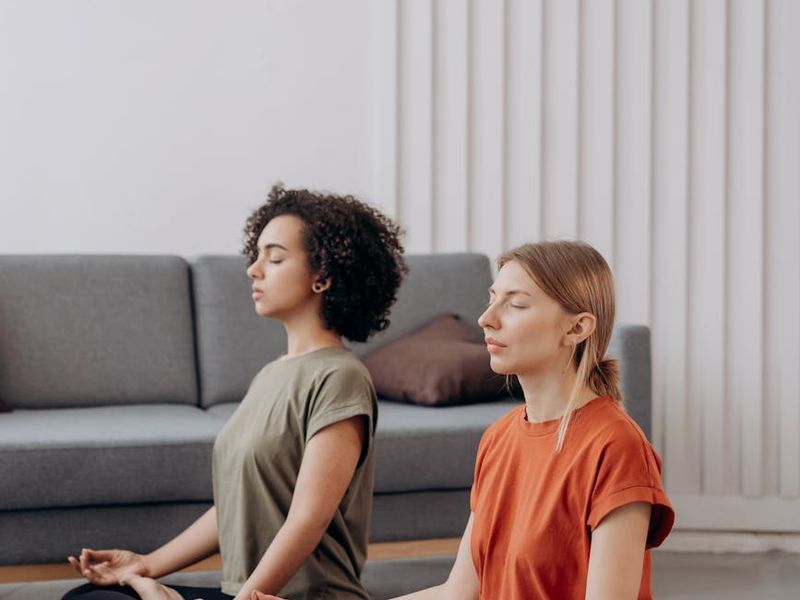 Person in a focused warrior yoga pose in a bright, airy room.